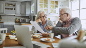 senior couple having breakfast and doing bills